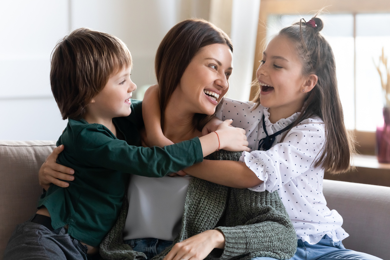 Happy small kids hug mom showing love